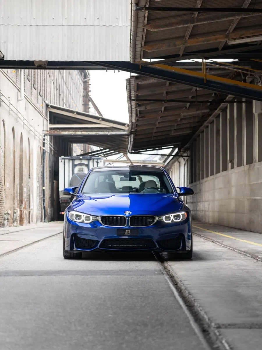 Blauer BMW M3 unter einer Brücke